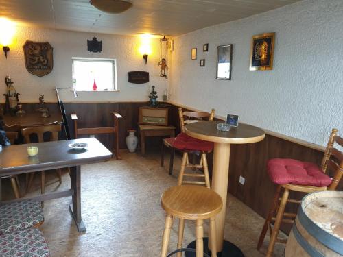 a restaurant with tables and stools in a room at Pension Zum Adler in Limbach