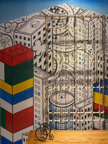 a wall mural of a building with a city at 3 Door Hotel in Tainan