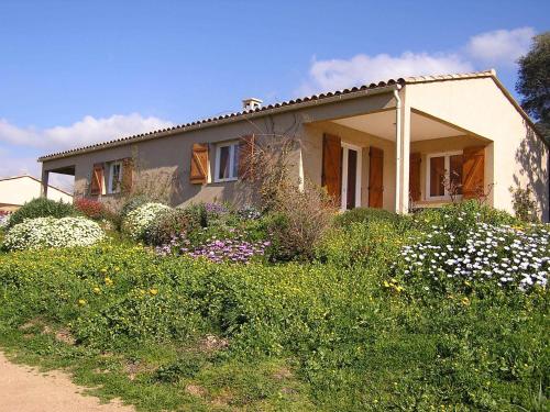a house with a field of flowers in front of it at Residence Cucunacciu in Cargèse