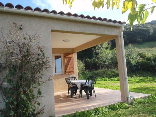 a patio with a table and chairs on it at Residence Cucunacciu in Cargèse