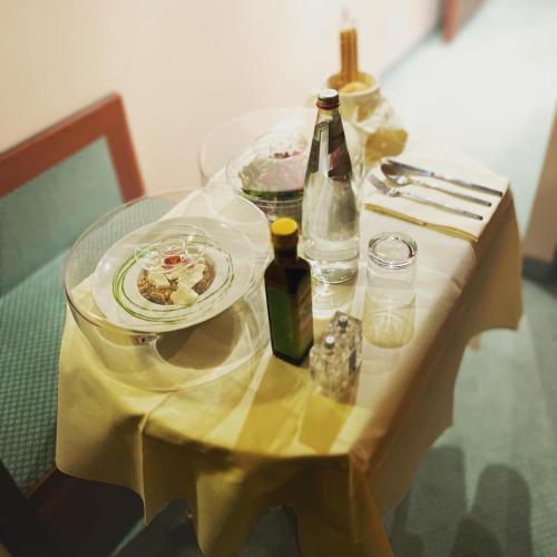 a table with a plate of food and bottles on it at Hotel Diana in Valdobbiadene
