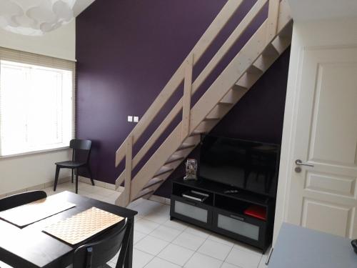 a living room with a staircase and a table at L' Atelier de la Monnaie in Crémieu