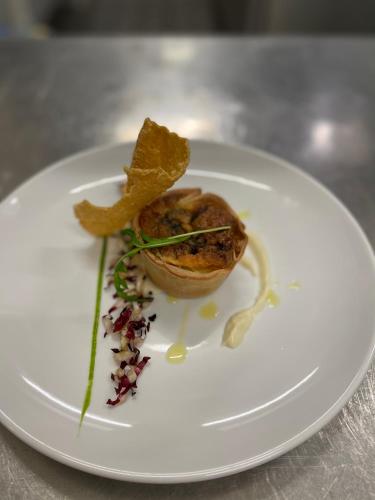 a white plate with a piece of food on it at Hotel Diana in Valdobbiadene