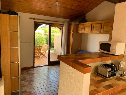 - une cuisine avec un comptoir et un four micro-ondes dans l'établissement Mini villa climatisée - Vue mer - Mer à 50 m - Jardin et 2 terrasses 300 m2, à Lumio