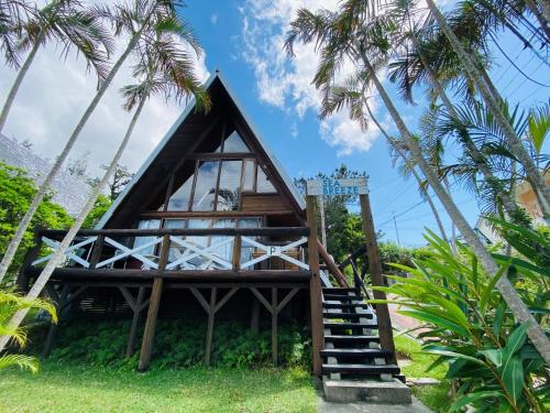 a house on the beach with palm trees at Sea Breeze in Onna