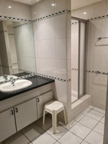 a bathroom with a sink and a shower and a stool at 6-8 pers appartement Résidence Durbuy in Durbuy