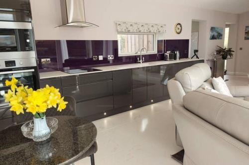 a kitchen with a couch and a table with yellow flowers at The Causeway in Bracadale