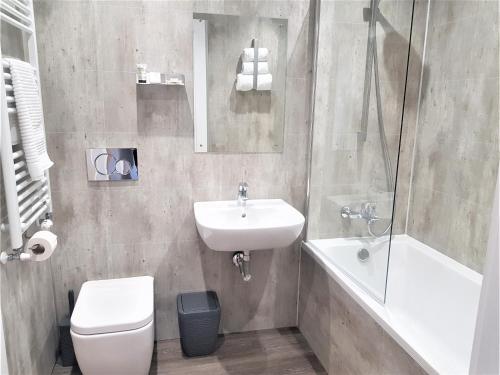 a bathroom with a sink and a toilet and a shower at Hunters Holiday Cottage in Saint Boswells