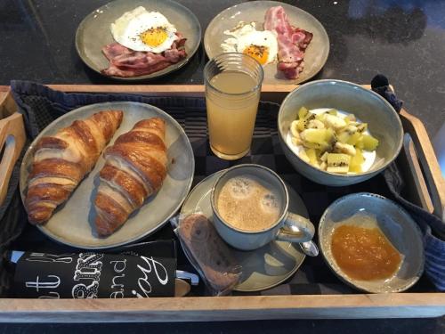 a tray with plates of breakfast foods and drinks at B&B Den Biesthoek in Grimbergen