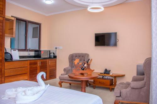 a room with a bed and a tv and a swan at Hotel Comster Mtwapa in Mtwapa