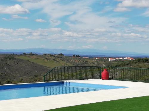 a swimming pool with a view of a hill at Casa Dos Xarês in Rosmaninhal