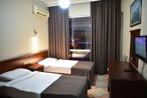 pokój hotelowy z 2 łóżkami i oknem w obiekcie Temiz Hotel w mieście Alanya