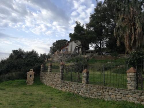 a stone fence in front of a house at Villa Haris in Sarti