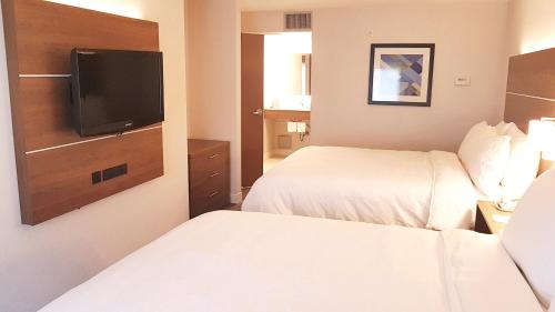 a hotel room with two beds and a flat screen tv at Holiday Inn Express and Suites Surrey by IHG in Surrey