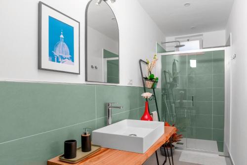 Un baño con lavabo blanco y ducha. en Villa Amura - Due Golfi, en SantʼAgata sui Due Golfi