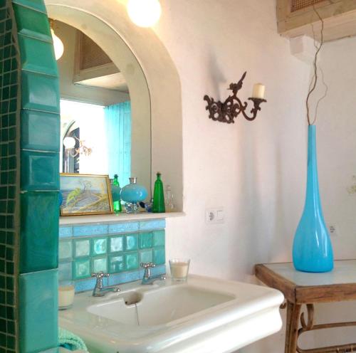 łazienka z umywalką i niebieską wazą w obiekcie JUDERIA LUXURY SUITE Casas Vejer Debra w mieście Vejer de la Frontera