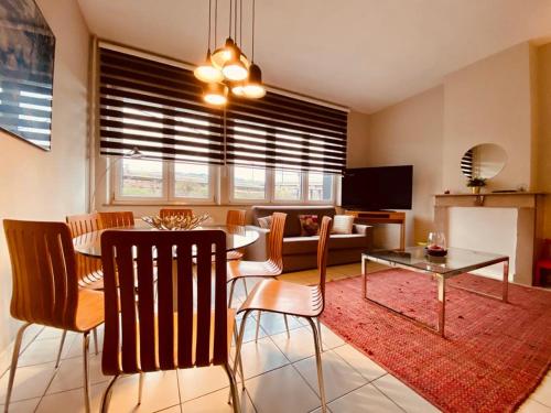 uma sala de estar com uma mesa e uma sala de jantar em Fenêtre sur le Standard de Liège em Ougrée