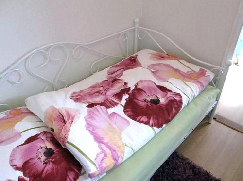 アルテンアウにあるFerienwohnung Himmelblau - Altenau Harzの白いベッド(ピンクの花付)