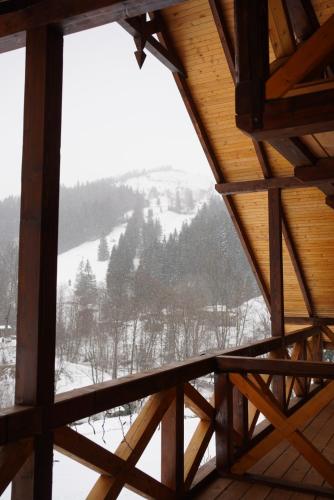 a view of a snowy mountain from a wooden roof at Терношорська Лада in Snidavka