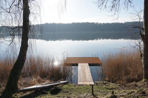 a dock on a lake with a boat on it at Wikno 3 Woda i Las in Wikno