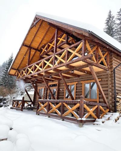 a log cabin in the snow with snow at Терношорська Лада in Snidavka