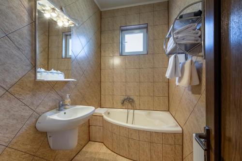 een badkamer met een wastafel, een toilet en een bad bij Hotel Denis in Daneş
