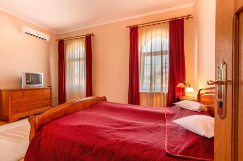 a bedroom with a bed with a red blanket at Hotel Denis in Daneş