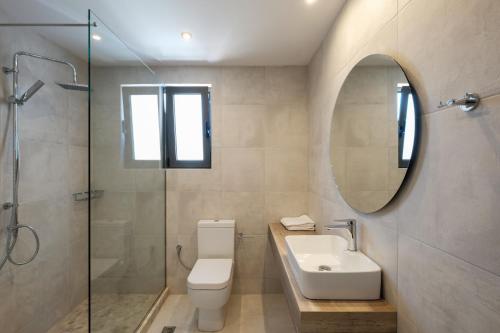 a bathroom with a toilet and a sink and a mirror at Margo Beach Hotel in Gythio