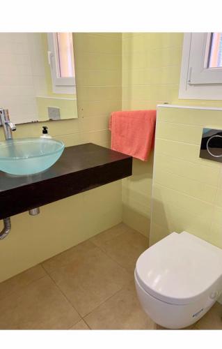 a bathroom with a sink and a toilet and a mirror at CASA DUPLEX BUNGALOW Dénia in Denia