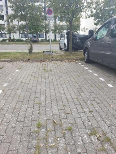 a parking lot with cars parked next to a street at Kleine Hafenliebe in Fehmarn