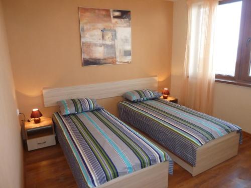 a bedroom with two beds and a window at Summer Breeze Villa in Balchik