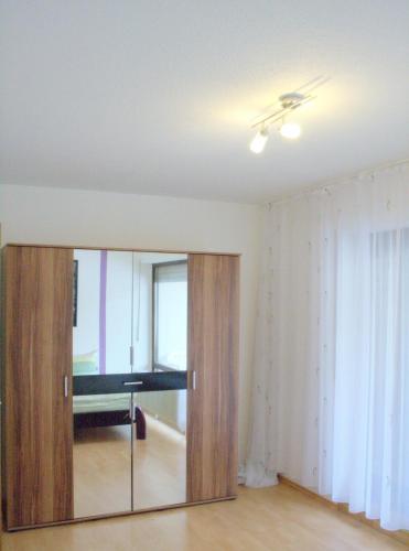 sala de estar con puerta corredera de cristal con espejo en Appartement Julija, en Baden-Baden