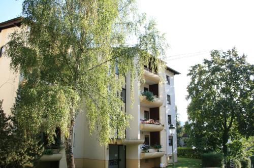 un edificio con un árbol delante de él en Appartement Julija, en Baden-Baden