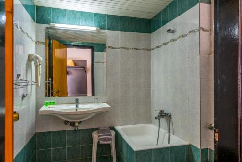 y baño con lavabo, espejo y bañera. en Alexios Hotel en Ioánina
