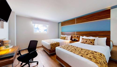 a hotel room with two beds and a desk at Sleep Inn Queretaro in Quer&eacute;taro