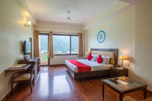 a bedroom with a bed and a desk and a window at Hotel Dewa Retreat- A Himalayan Boutique Hotel in Rishīkesh