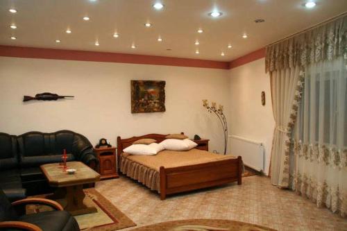 salon z łóżkiem i kanapą w obiekcie Pensiunea Club Castel Resita w mieście Reşiţa