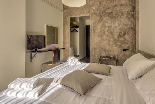 a large white bed in a bedroom with a stone wall at Alexios Hotel in Ioannina