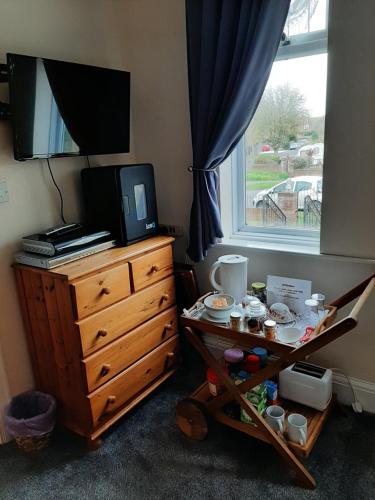 a bedroom with a dresser with a television on top of it at Nest Guesthouse in Margate