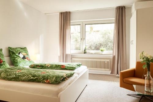 Schlafzimmer mit einem Bett mit grüner Bettwäsche und einem Fenster in der Unterkunft Ferienhaus Willkommen in Winterberg