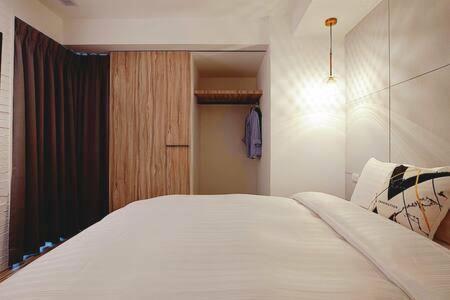 a bedroom with a large white bed and a closet at MU House in Taipei