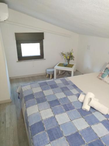 Un dormitorio con una cama azul y blanca y una ventana en Apartments Nina, en Ravni