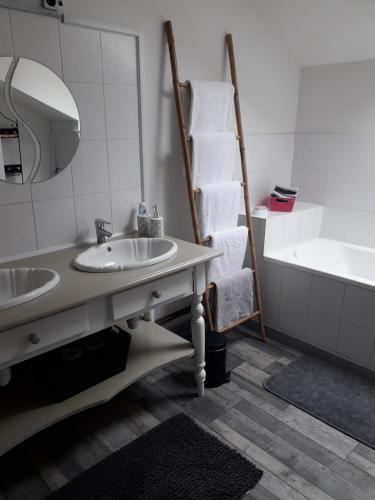 een badkamer met 2 wastafels en een bad bij gite du montagnard in Oxelaere