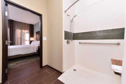 uma casa de banho com chuveiro e uma cama num quarto em Staybridge Suites Wichita Falls, an IHG Hotel em Wichita Falls