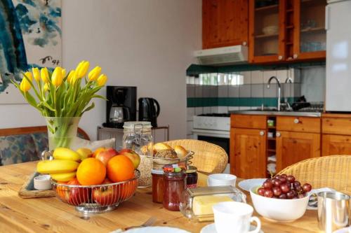 a wooden table with bowls of fruit on it at Ferienwohnung Familienzeit mit Sauna in Hohen Pritz