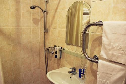 a bathroom with a sink and a shower with a mirror at Maxima Zarya Hotel in Moscow