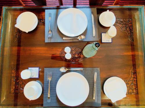 uma mesa com placas brancas e talheres em The Shelter Heritage A Boutique Hotel em Srinagar