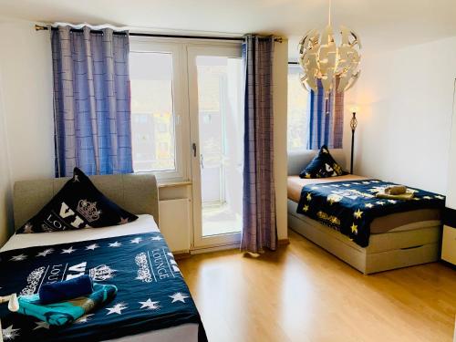 a bedroom with two beds and a chandelier at Big and Beautiful in Hannover