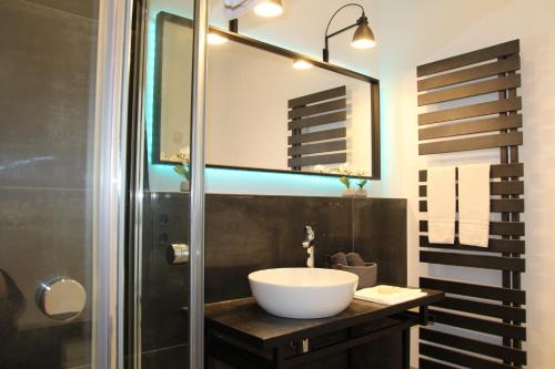 La salle de bains est pourvue d'un lavabo et d'un miroir. dans l'établissement Mosel-Loggia - Luxusapartment -Terrass - Klimaanlage, à Traben-Trarbach