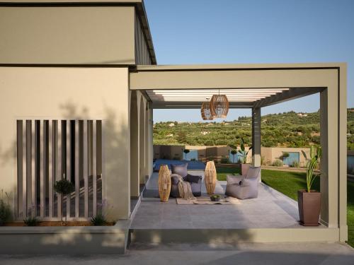 a patio with couches and chairs in a house at Minas Sublime Villa, a Magical Sanctuary, By ThinkVilla in Kipseli